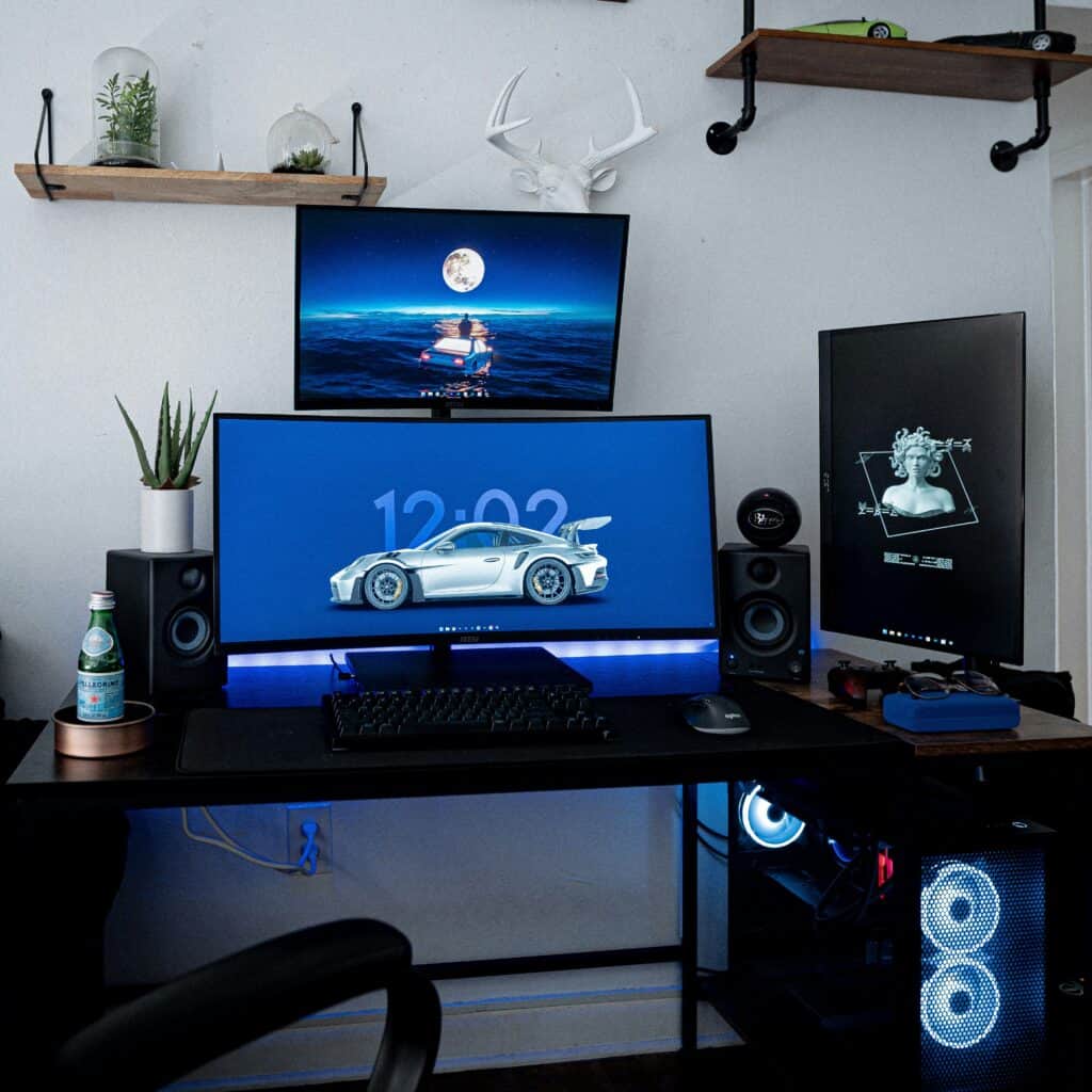 Three large monitors connected to a keyboard