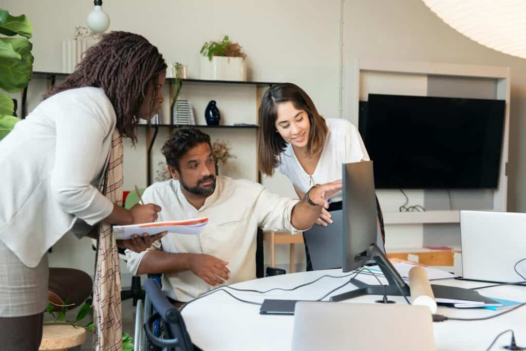 People discussing their website, looking at a monitor.