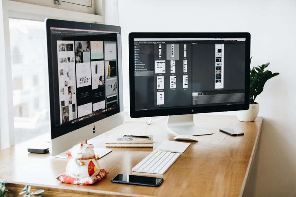 Two large monitors and a keyboard on a desk